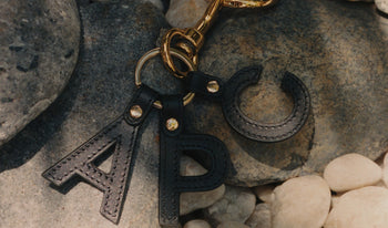 A.P.C. Men's Other Accessories - Man wearing patterned swim trunks in a backyard patio.