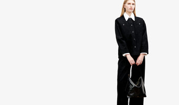 A.P.C. Women's Pants - Woman wearing checkered dress holding denim tote bag standing by a pool.