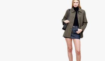 A.P.C. Women Skirts, Shorts - Woman standing on bridge wearing coat and jeans.