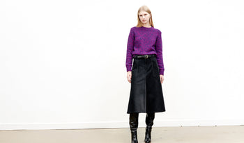 A.P.C. Women Sale Skirts, Shorts - Woman standing on bridge wearing coat and jeans.