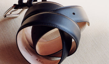 A.P.C. Women's Belts - Rolled up belt on wooden surface.