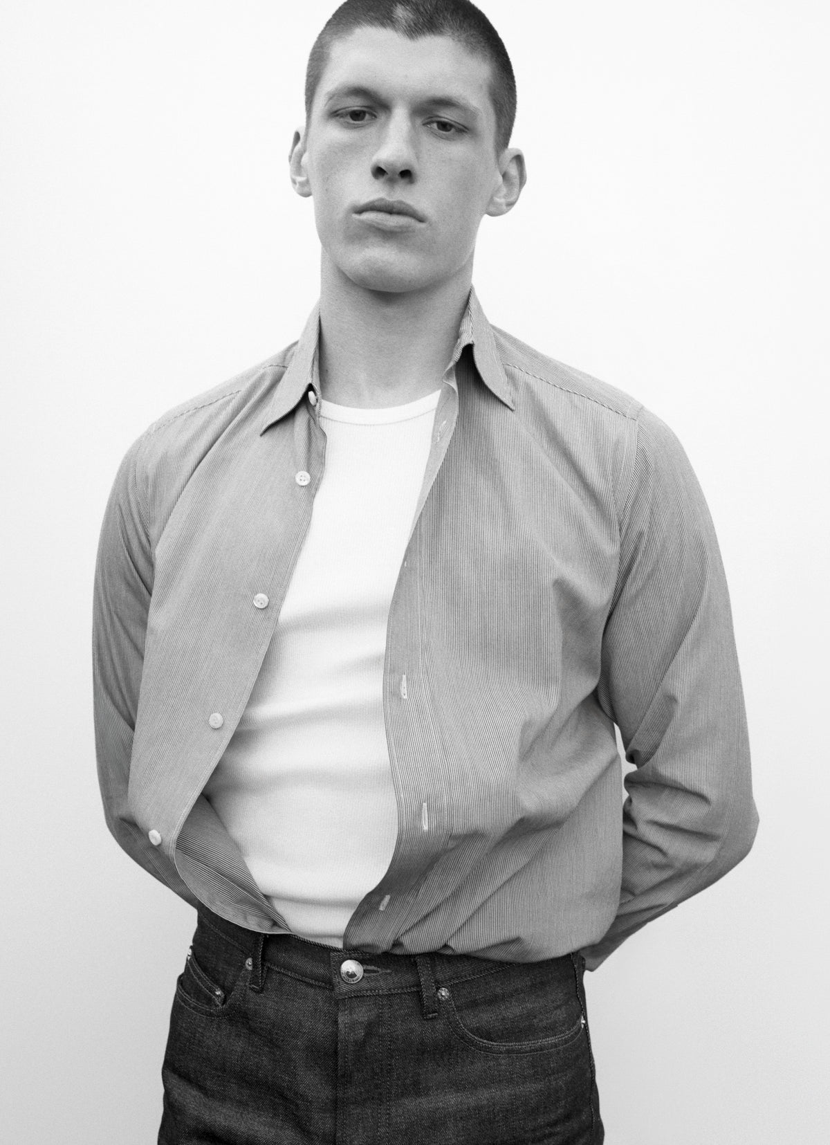 man wearing striped button down and blue jeans