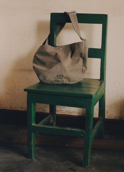Green satchel bag on green chair.