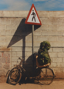 Bike carrying bananas next to a pedestrian crossing sign