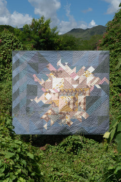 Quilt suspended among plants in jungle