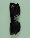Sunglasses on light green background
