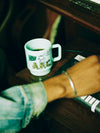 A.P.C. x Brain Dead mug on a desk