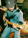 Man wearing cap and denim playing guitar