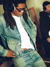 Man wearing denim jacket and jeans with headphones