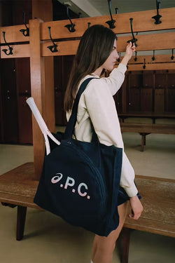 A.P.C. Asics - woman model wearing a tennis tote in a locker room