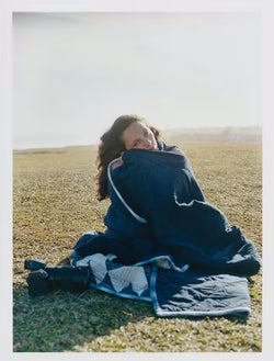 female model with a blanket in a meadow