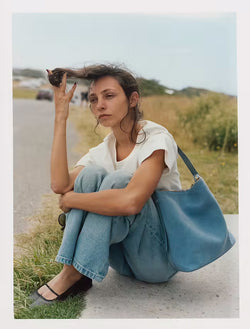 female model sitting by the road