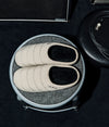 A.P.C. x Subu - Beige Subu slippers on stool in music studio.