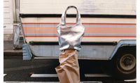 silver APC tote bag on top of kraft paper roll